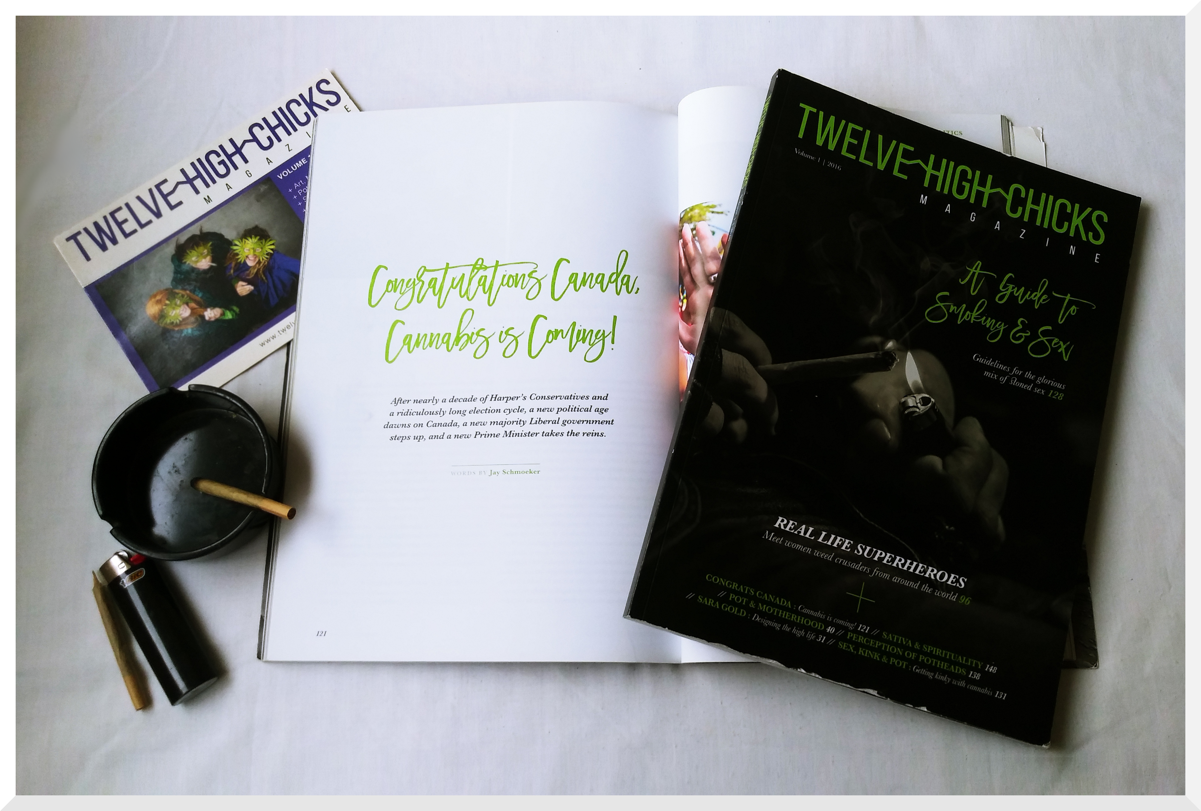 A copy of cannabis advocacy publication "Twelve High Chicks Magazine" lies open to show a Canada cannabis legalization article visible under another closed copy with a black and green cover. An ashtray, joints, and "Twelve High Chicks" marketing postcard sit next to them.